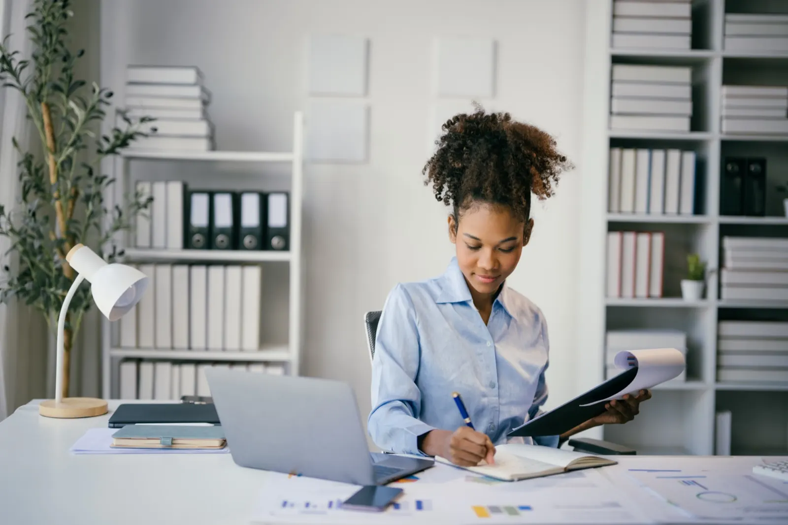 Accountant reviewing records at her desk in a bright office