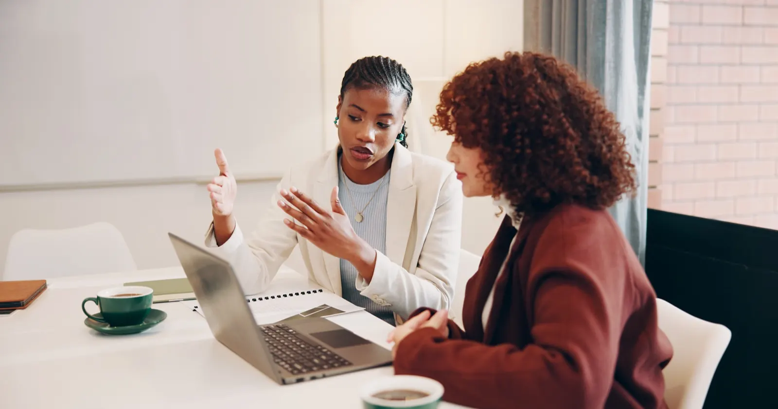Two professionals in a strategy session over a laptop