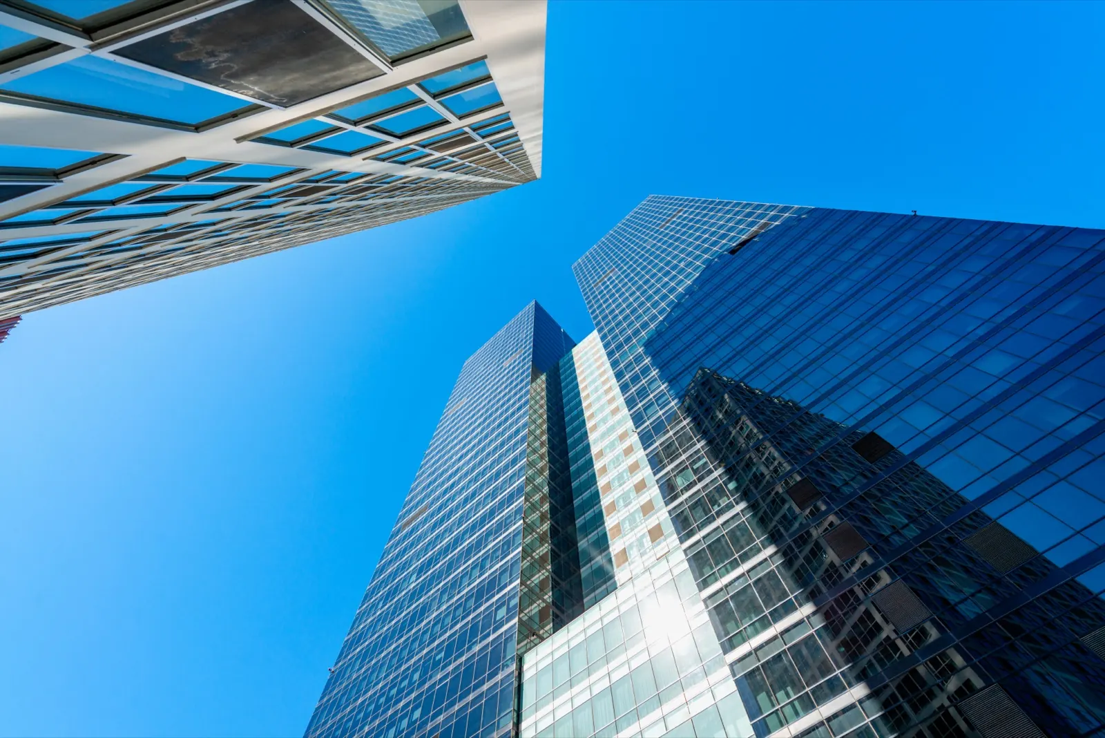 Glass office towers against a blue sky